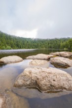 Rock formations in the lake with forest background and cloudy sky, Mummelsee, Seebach, Ortenau
