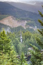 View over a wooded valley with mountain scenery and buildings between the trees, Mummelsee,