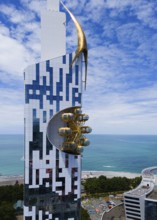 Futuristic building with golden element and golden gondolas on the coast overlooking the sea,