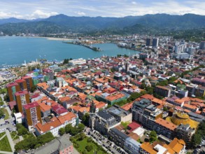 Panoramic view over the city with colourful roofs and mountains in the background, aerial view,