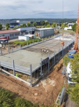 Panoramic view of a construction site with partially erected building structure and crane in the