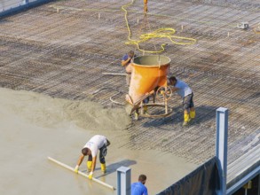 Close-up of workers concreting on a construction site under a crane, car park construction, Calw,