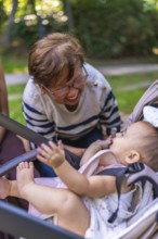Grandmother enjoys a playful moment with her granddaughter, creating a heartwarming scene of family