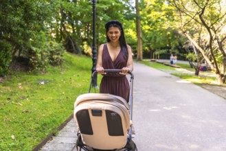 Latin mother pushing a stroller with a happy baby inside, enjoying a sunny day while walking