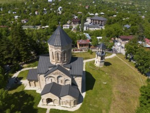 Aerial view of a church with surrounding buildings and green vegetation in a village, aerial view,