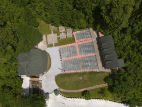 A bird's eye view of an amphitheatre with seats embedded in a wooded landscape, aerial view, Green