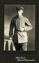 Young man with simple uniform, studio photograph, around 1910