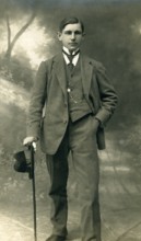 Elegant young man with hat and walking stick, studio photograph, around 1910