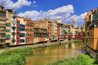 Red bridge over the river Onyar built by the Eiffel company, colourful facades over the river