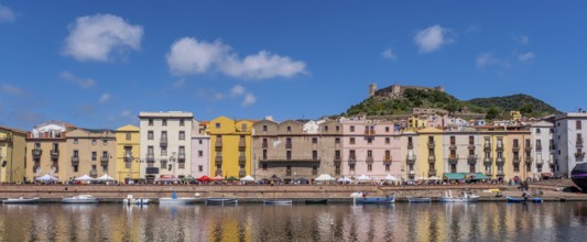 Sardinia, panoramic photo with houses and promenade on the river Temo, guests at the restaurants