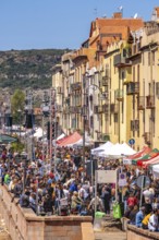 Sardinia, boats in the river Temo and houses on the promenade, guests at the restaurants with