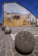 Sardinia, stone balls in front of a house with mural (Murales) Sardinia sight, Tinnura, Europe,