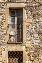 Sardinia, house facade with balcony and weathered wooden balcony door, brown balcony lattice, Santu