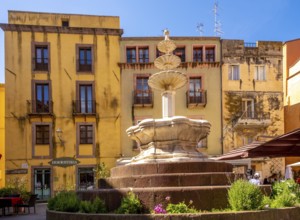 Sardinia, artistic fountain with three levels on the Piazza Costituzione, house wall with