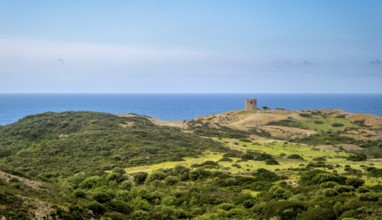 Sardinia, Former fortress tower, hilly coastal landscape by the sea, blue sky with clouds, Bosa,