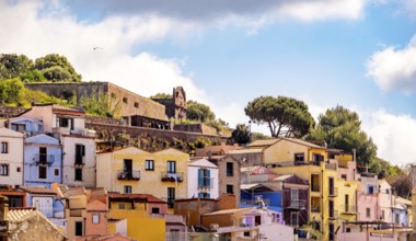 Sardinia, picturesque view of Bosa with pavilions on the promenade, residential buildings and