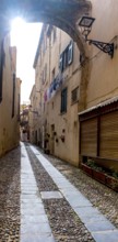 Sardinia, Narrow cobblestone alley and houses in the old town, Laundry by the window, Alghero,