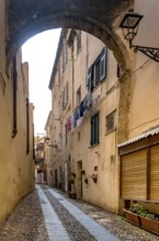 Sardinia, Narrow cobblestone alley and houses in the old town, Laundry by the window, Alghero,
