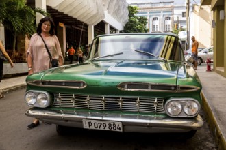 Vintage car, historic road cruiser, green Impala, streetlife in the city centre of Santa Clara at