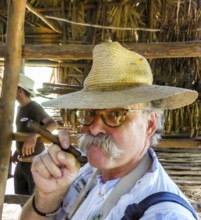 Hans Blossey Tourist smokes a Havana cigar, tobacco farm in the Vinalestal, Viñales, Cuba, Pinar