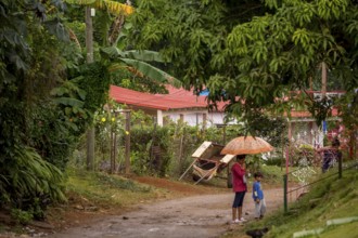 Street scene with woman and child and umbrella, Viñales, Cuba, Pinar del Río, Cuba, Viñales, Pinar