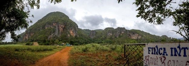 Red earth, finca, farmhouse below the overgrown hills in the Vinales Valley, Viñales, Cuba, Pinar