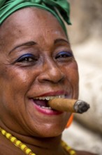 Old Cuban woman with green hair bow smokes a Havana cigar, Cuban woman with cigar and lacquered