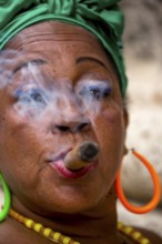 Old Cuban woman with green hair bow smokes a Havana cigar, Cuban woman with cigar and lacquered