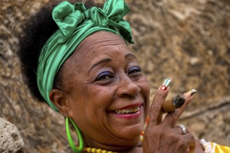 Old Cuban woman with green hair bow smokes a Havana cigar, Cuban woman with cigar and lacquered
