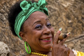 Old Cuban woman with green hair bow smokes a Havana cigar, Cuban woman with cigar and lacquered