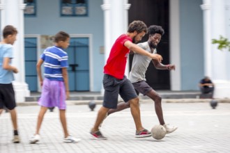 Cuban youths playing football in the marketplace, La Habana, Cuba, Caribbean, Central America,