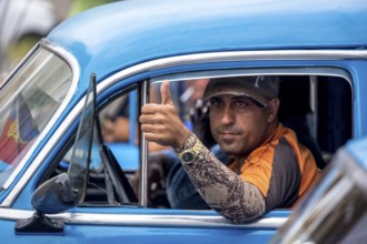 Taxi driver, blue vintage car in street scene, old American street cruiser on the streets of