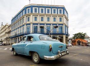 Turquoise-coloured vintage car in street scene, Old American street cruiser on the streets of
