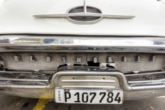 Radiator grille, white vintage car in street scene, Oldsmobile, Old American road cruiser on the