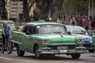 Green vintage car in street scene, Old American street cruiser on the streets of Havana, Taxi, La