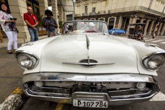 Radiator grille, white vintage car in street scene, Oldsmobile, Old American road cruiser on the
