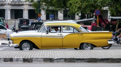 Yellow vintage car in street scene, Old American street cruiser on the streets of Havana, Taxi, La