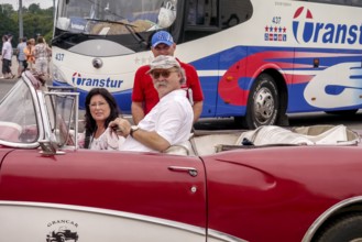 Tourists in a red convertible, red vintage convertible in the street scene, old American road