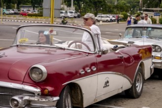 Tourists in a red convertible, red vintage convertible in the street scene, old American road