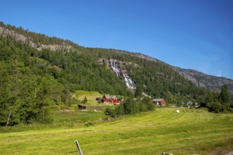 Red mountain huts, meadows, trees, waterfall, mountains, blue sky, Skulestadmo, Hordaland, Norway,