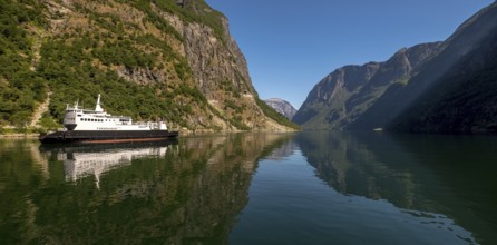Excursion ship on a fjord, Flåm, Gudvangen, rock walls, trees, blue sky, Sogn og Fjordane, Norway,