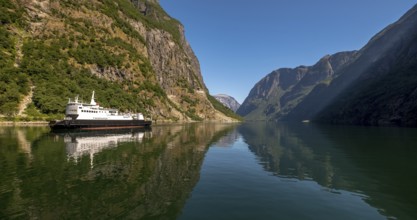Excursion ship on a fjord, Flåm, Gudvangen, rock walls, trees, blue sky, Sogn og Fjordane, Norway,