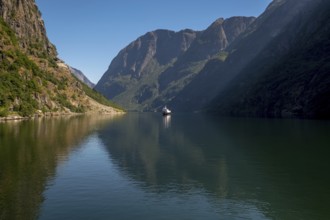 Excursion ship on a fjord, Flåm, Gudvangen, rock walls, trees, blue sky, Sogn og Fjordane, Norway,