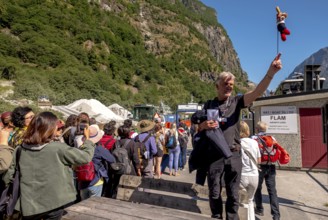 Travel guide with mascot at mountain hut station, mountains, construction site, construction site