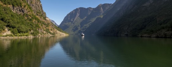 Excursion ship on a fjord, Flåm, Gudvangen, rock walls, trees, blue sky, Sogn og Fjordane, Norway,