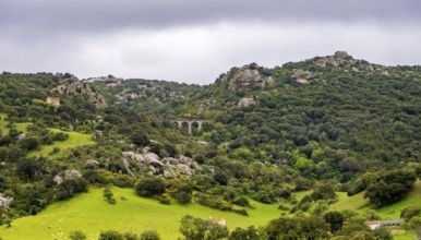 Sardinia, rugged granite mountains of Gallura, quarries and viaduct in hilly landscape, Olbia,