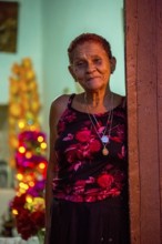 Old lady looks friendly out of her front door, Street scene in the old town of Trinidad, Trinidad,