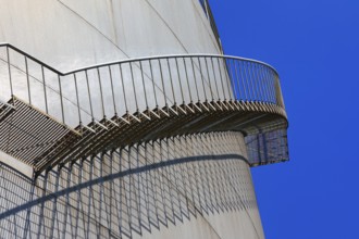Metal staircase with striking shadow play on the side of a large tank, elevated tank, chemical,