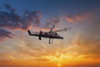 A helicopter hovers elegantly in front of a brightly coloured sunset sky, transport helicopter,