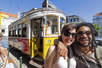 Portuguese tourist couple in front of tram 28, Lisbon, Lisbon district, Portugal